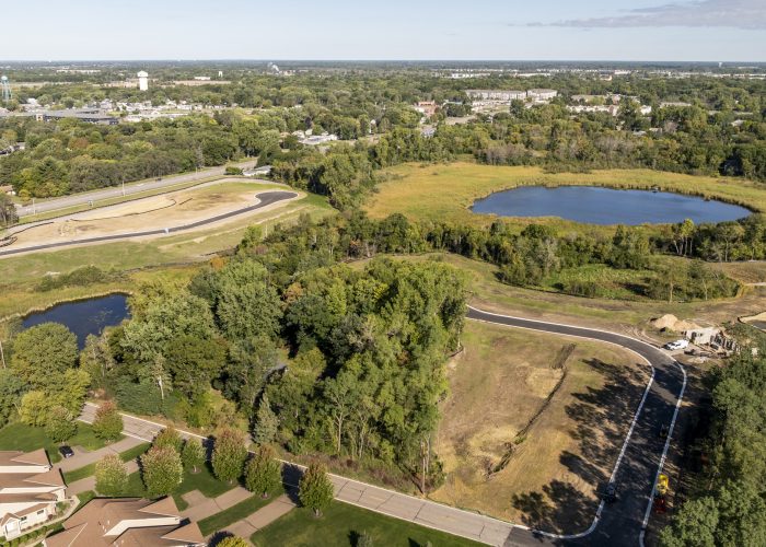 Aerial view of new roads, ponds, and wooded neighborhood