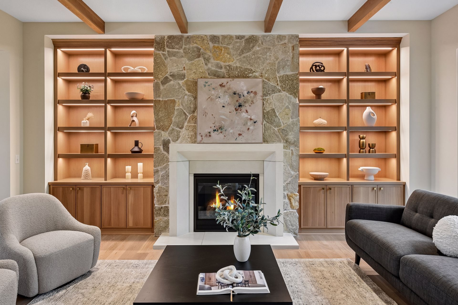 Modern living room with stone fireplace and illuminated built-ins