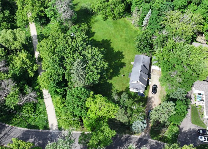 Aerial view of a lush green backyard with a house and surrounding trees at 5570 Wedgewood Drive.